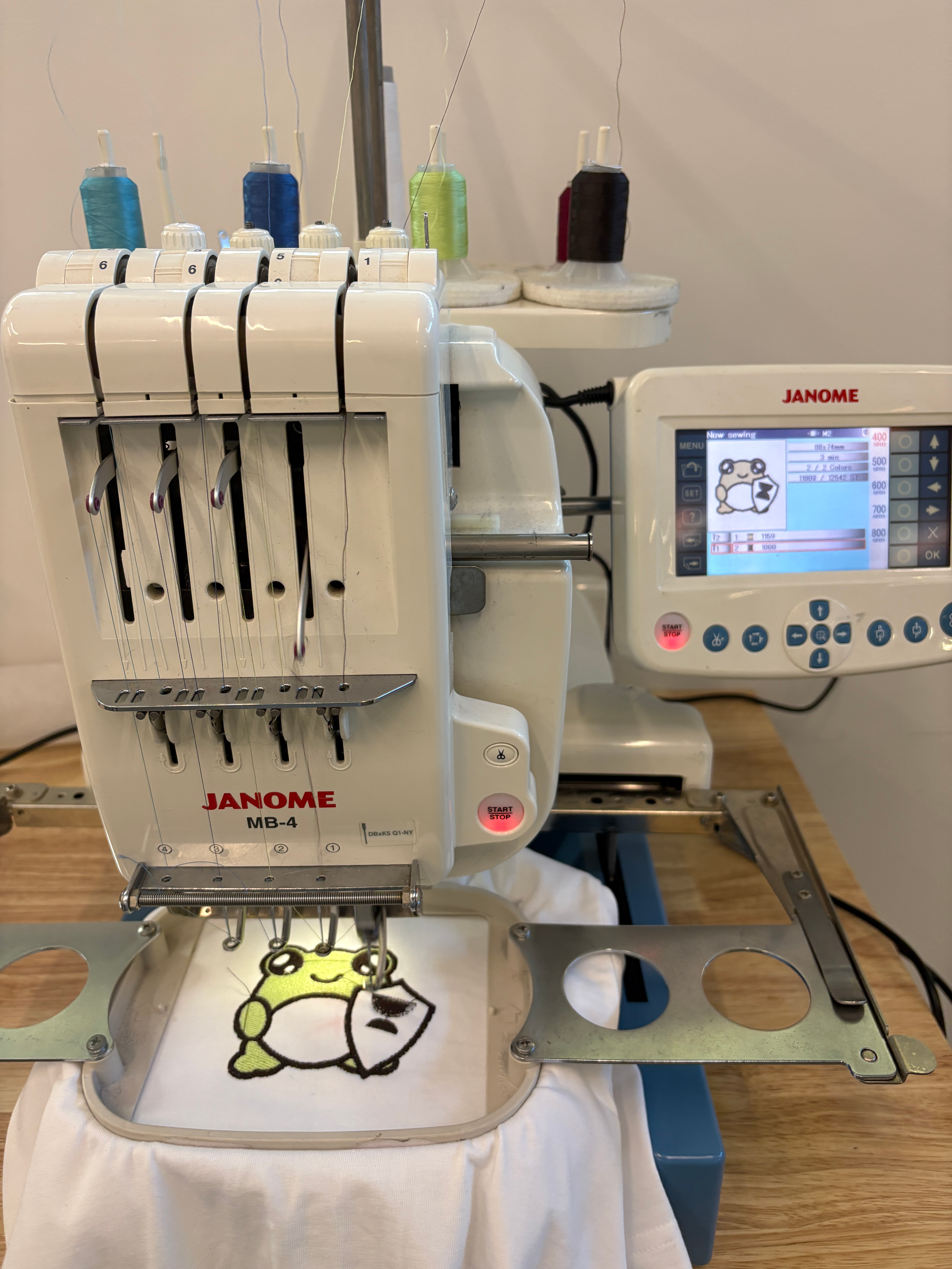 Embroidery machine stitching a frog design